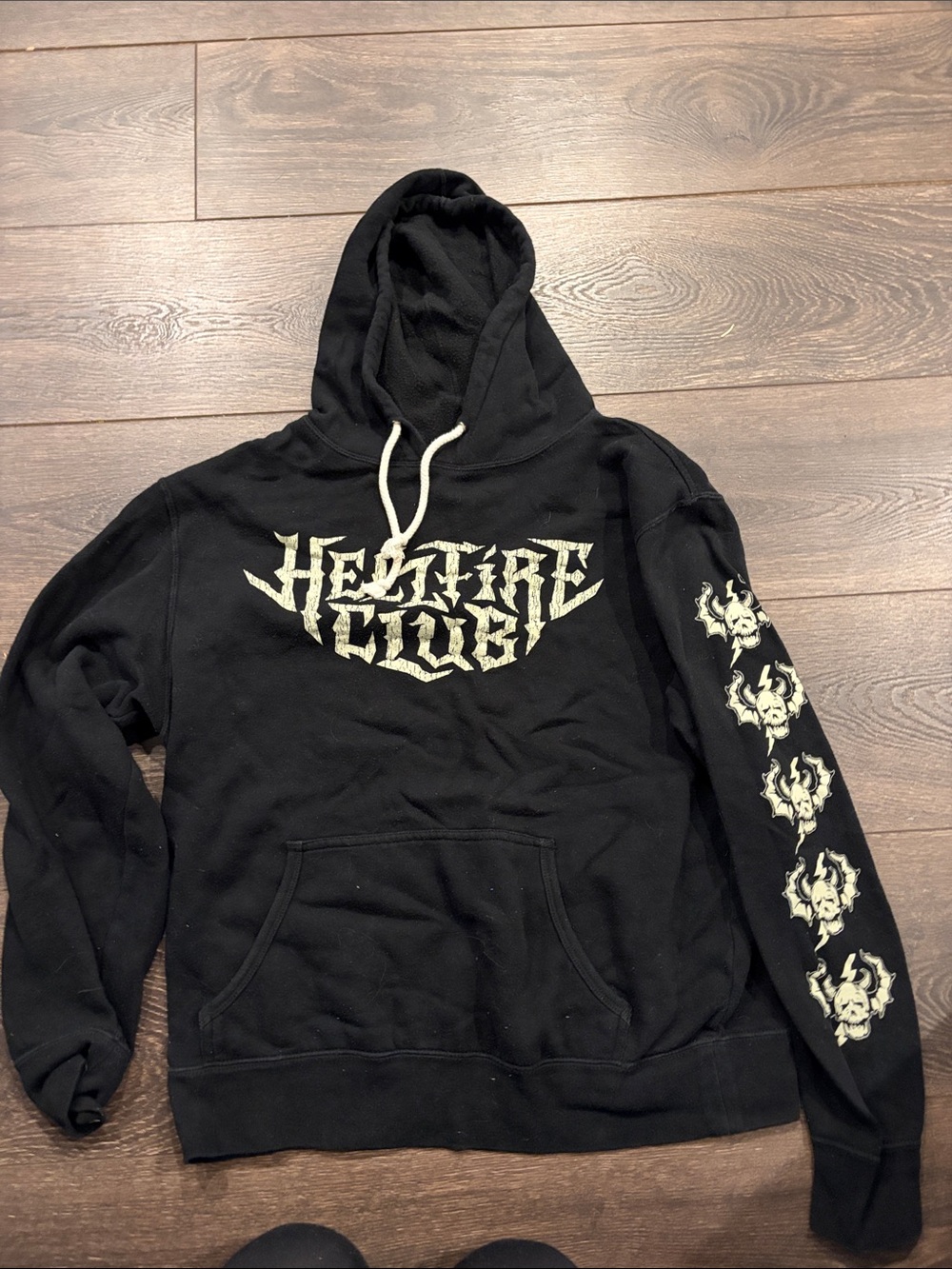 Black Graphic Pullover Hoodie with Pale Cream Crest and Sleeve Motifs